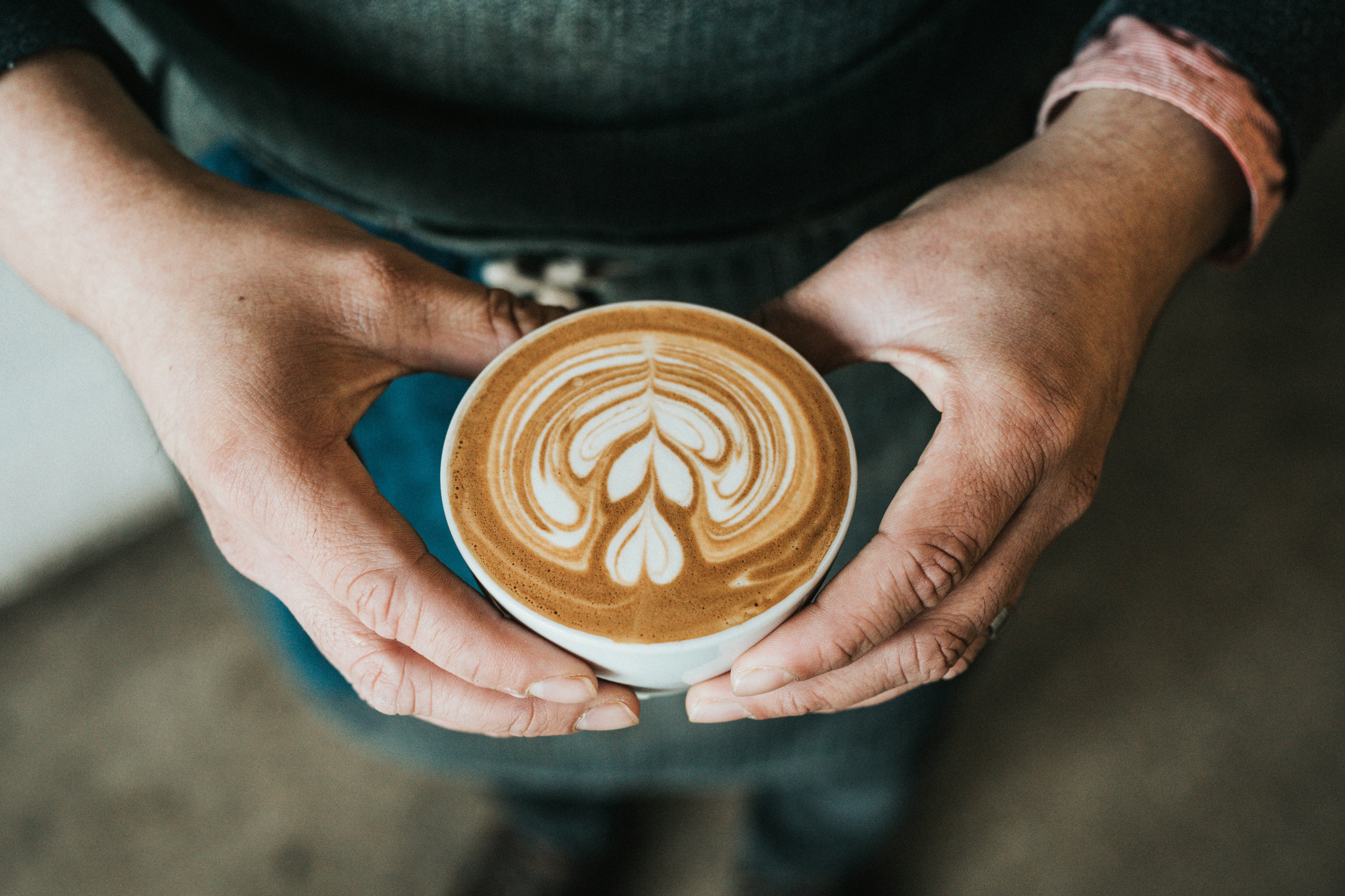 Kaffeetasse in den Händen einer Person